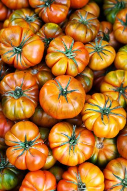 Pile of ripe raf tomatoes on the market, vegetable background top view, healthy food.