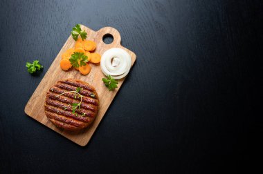 Sebzesiz sağlıklı yiyecek, ızgara vejetaryen et tabanlı havuç ve siyah arka planda soğan, kopyalama alanı..