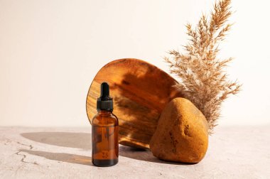 Yüz serumlu cam bir şişe, gerekli yağ veya taş ve ahşap plakalı retinol, doğal kaplıca konsepti..