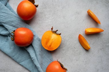 Hurmalar gri bir masada, tekstil ve Sharon kamaları, üst görünüm..