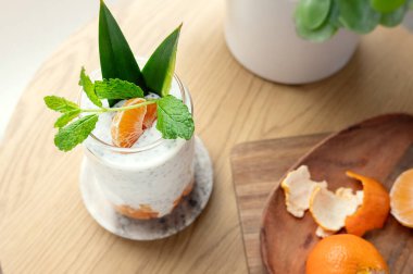 Yoğurttan Chia pudingi ya da ahşap masada taze Clementine ile vejetaryen sütü..