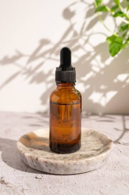 Cilt rutini, üzerinde C vitamini ya da retinol ya da gri arka planda aromatik yağ bulunan yüz serumu şişesi..