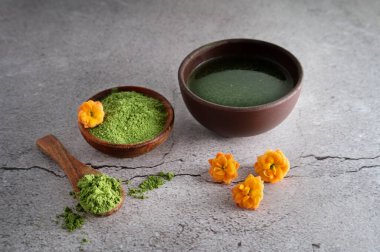Klorella spirulina ve genç arpa otu veya yeşil kibrit, beton arka planda detoks içeceği.