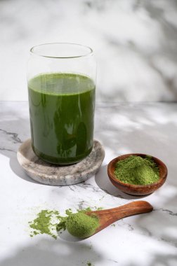 Bir bardak taze arpa ve klorella spirulina ya da kasede toz ve kaşıkla kibrit çayı..