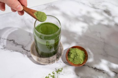 Genç arpa ve klorella spirulina tozu ya da bir bardağa kibrit. en üstteki görünüm.