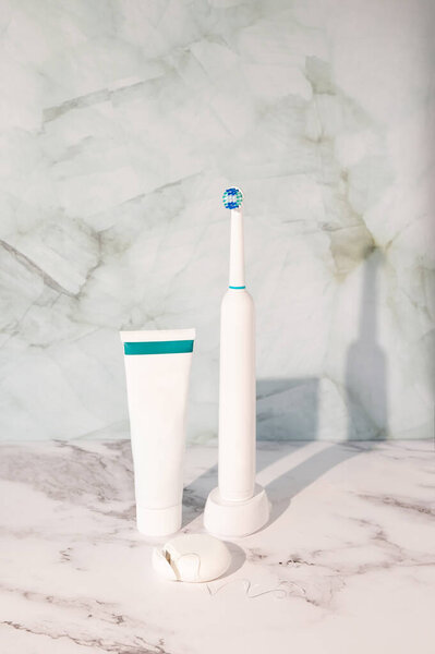 Electric Toothbrush Paired Tube Toothpaste Floss White Marble Surface Dental Royalty Free Stock Photos