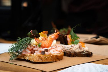 Geleneksel Danimarka usulü karides, kremalı mayonez ve otlarla birlikte koyu çavdar ekmeği ve aromalı açık sandviç çifti..