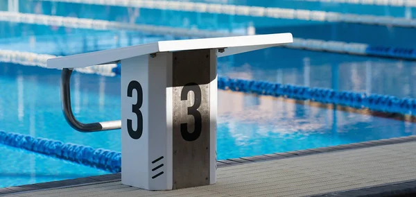 水泳のレースや競技のための数3でプラットフォームを開始します スイミングプールスタートブロック3番 スポーツと水泳のコンセプト — ストック写真