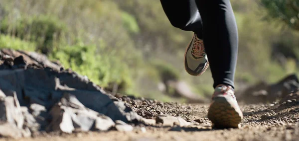 Trail running athlete exercising for fitness and health outdoors on mountain pathway, closeup of running shoes in action