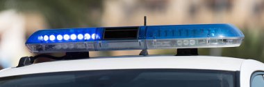 Sokakta devriye arabasının mavi ışığındaki teşhirci. Acil durumlar için araçlardaki acil durum sirenleri, polis arabasının çatısındaki mavi ışıkların kapatılması