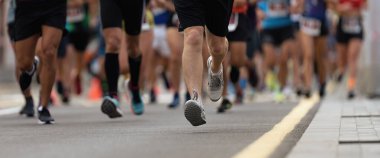 Şehir yolda, büyük grup koşucu çalıştıran maraton koşucu