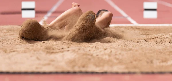 Atleta Fêmea Salto Longo Pouso Pulverizador Areia Pousando Salto Longo — Fotografia de Stock