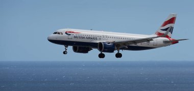 Tenerife, İspanya 27 Temmuz 2023. British Airways Airbus a320 Tenerife Uluslararası Havaalanına iniyor. British Airways okyanusun üzerinde mavi gökyüzünde uçuyor.