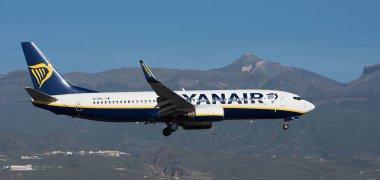 Tenerife, İspanya 15 Aralık 2023. Boeing 737-8AS Ryanair Havayolları mavi gökyüzünde uçuyor. Tenerife Havaalanına iniyor. Arka planda El Teide volkanı