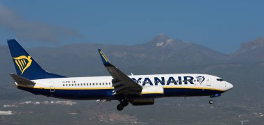 Tenerife, İspanya 15 Aralık 2023. Boeing 737-8AS Ryanair Havayolları mavi gökyüzünde uçuyor. Tenerife Havaalanına iniyor. Arka planda El Teide volkanı