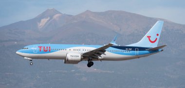 Tenerife, İspanya 13 Ocak 2024 Boeing 737 MAX 8 TUI Havayolları gökyüzünde uçuyor. Tenerife Havaalanına iniyor. Arka planda El Teide volkanı