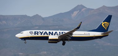 Tenerife, İspanya 13 Ocak 2024. Boeing 737-8AS Ryanair Havayolları mavi gökyüzünde uçuyor. Tenerife Havaalanına iniyor. Arka planda El Teide volkanı