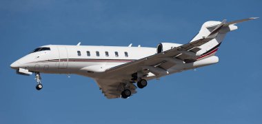 Tenerife, İspanya 13 Ocak 2024. Bombacı Challenger 350 NetJets Avrupa Havayolları mavi gökyüzünde uçuyor. Tenerife Havaalanına iniyor.