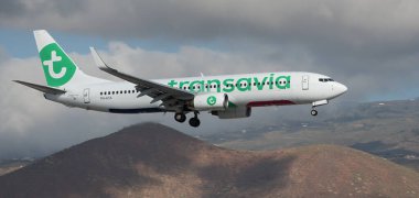Tenerife, İspanya 11 Şubat 2024. Boeing 737-8K2 Transavia Havayolları kara bulutlarda uçuyor. Tenerife Havaalanına iniyor.