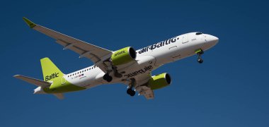 Tenerife, İspanya 21 Şubat 2024. Airbus A220-300 Air Baltic Airlines mavi gökyüzünde uçuyor. Tenerife Havaalanına iniyor.