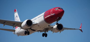 Tenerife, İspanya 21 Şubat 2024. Boeing 737 MAX 8 Norveç Havayolları mavi gökyüzünde uçuyor. Tenerife Havaalanına iniyor.
