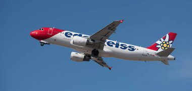 Tenerife, İspanya 14 Şubat 2024. Airbus A320-214 Edelweiss Hava Yolları mavi gökyüzünde uçuyor. Tenerife Havalimanı 'ndan kalkış
