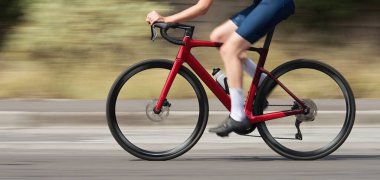 Bisiklet yarışının hareket bulanıklığı ve motosiklet sürücüsü yüksek hızda. Açık havada bisiklet sürerken yarış kıyafeti giymiş profesyonel bir bisikletçi. Kullanılan tarama tekniği