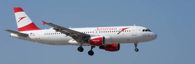 Tenerife, İspanya 1 Şubat 2024. Airbus A320-214 Avusturya Havayolları mavi gökyüzünde uçuyor. Tenerife Havaalanına iniyor.