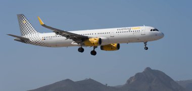 Tenerife, Spain February 1st, 2024. .Airbus A321-231 Vueling Airlines flies in the blue sky. Landing at Tenerife Airport clipart