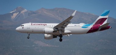 Tenerife, Spain March 30st, 2024. Airbus A320-214 Eurowings Airlines flies in the blue sky. Landing at Tenerife Airport. El Teide volcano in the background clipart