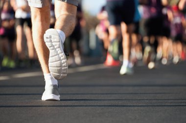 Maraton gün ışığında koşuyor. Şehir yolundaki insanlar