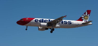 Tenerife, İspanya 2 Mayıs 2024. Airbus Airbus A320-214 Edelweiss Hava Yolları mavi gökyüzünde uçuyor. Tenerife Havaalanına iniyor.