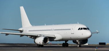 Kalkış için beyaz uçak, kalkış için uçak taksisi. Beyaz yolcu jeti havaalanında pist boyunca ilerliyor.