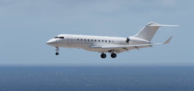 Uçak okyanusun üzerine iniyor. Özel uçak. Ticari reklam. Plajın yanındaki havaalanına iniyor. Uçak deniz sahilinde son derece alçaktan uçuyor.