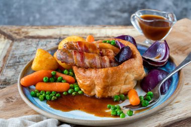 Kurbağa deliğinde Yorkshire pudingi, sosis ve sebzelerle