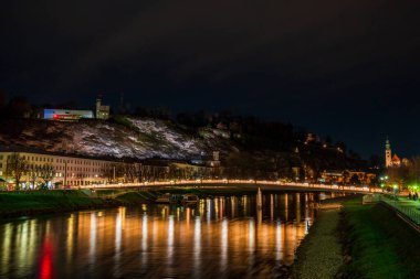 Salzburg, Avusturya 'da Salzach Nehri' nin karşısındaki gece manzarası