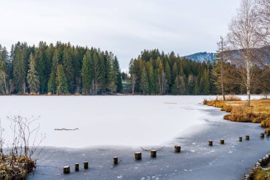 Schwarzsee lake in Kitzbuhel covered with ice and snow. Winter in Austria