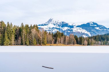 Schwarzsee lake in Kitzbuhel covered with ice and snow. Winter in Austria