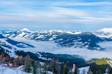 Panoramic aerial view of wintry landscape in Austrian Alps above low clouds covering Kitzbuhel in Austria