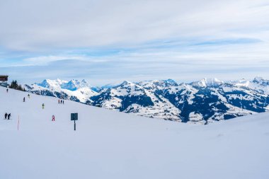 KITZBUHEL, AUSTRIA - JANUARY 12, 2023: Skiers enjoy winter sport on the slopes of Hahnenkamm mountain in Kitzbuhel, fashionable winter resort known for the annual Hahnenkamm downhill race