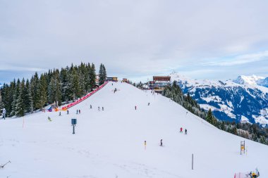 KITZBUHEL, AUSTRIA - JANUARY 12, 2023: Skiers enjoy winter sport on the slopes of Hahnenkamm mountain in Kitzbuhel, fashionable winter resort known for the annual Hahnenkamm downhill race
