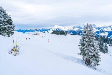 KITZBUHEL, AUSTRIA - JANUARY 12, 2023: Skiers enjoy winter sport on the slopes of Hahnenkamm mountain in Kitzbuhel, fashionable winter resort known for the annual Hahnenkamm downhill race