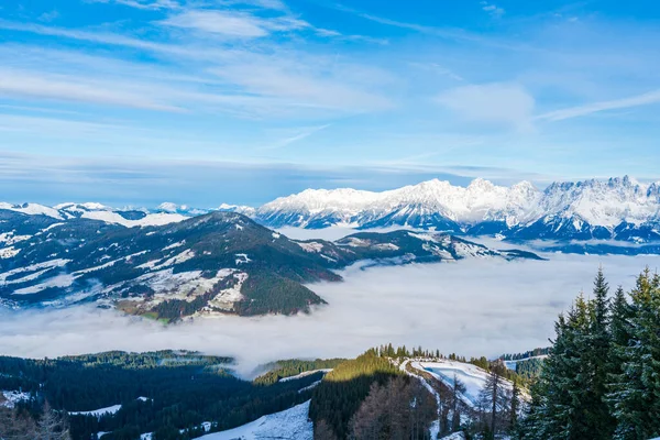Aerial view of wintry landscape in Austrian Alps above low clouds covering Kitzbuhel in Austria