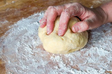 Kadının eli hamur yoğurur.