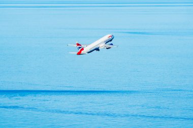 GIBRALTAR, İngiltere - 12 Mart 2023: British Airways uçağı Gibraltar Uluslararası Havaalanı 'ndan havalandıktan sonra denizin üzerinde uçar. Cebelitarık bir İngiliz Denizaşırı Toprakları.