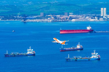 GIBRALTAR, İngiltere - 12 Mart 2023: EasyJet uçağı Cebelitarık Uluslararası Havalimanı 'ndan havalandıktan sonra denizin üzerinde uçar. Cebelitarık bir İngiliz Denizaşırı Toprakları.