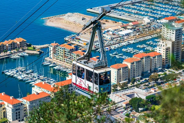 stock image GIBRALTAR UK - MARCH 12 2023: Cable car takes tourists up the Gibraltar Rock which offers spectacular views over the town, harbour and on a clear day coast of Africa and Spain across the Gibraltar Bay