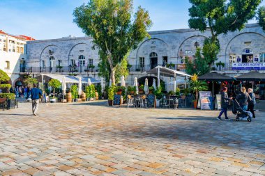 GIBRALTAR, İngiltere - 10 Mart 2023: Turistler Gibraltar kasabasında tatilin ve güneşli havanın tadını çıkarıyorlar. Cebelitarık bir İngiliz Denizaşırı Toprakları ve popüler bir turizm beldesidir.