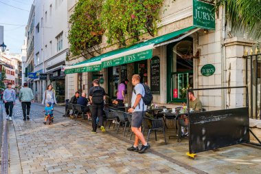 GIBRALTAR, İngiltere - 10 Mart 2023: Turistler Gibraltar kasabasında tatilin ve güneşli havanın tadını çıkarıyorlar. Cebelitarık bir İngiliz Denizaşırı Toprakları ve popüler bir turizm beldesidir.