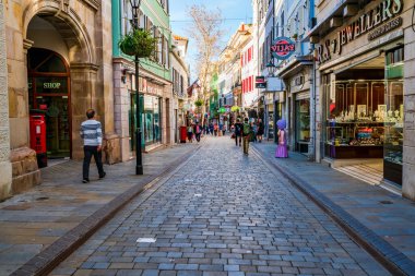 GIBRALTAR, İngiltere - 10 Mart 2023: Turistler Gibraltar kasabasında tatilin ve güneşli havanın tadını çıkarıyorlar. Cebelitarık bir İngiliz Denizaşırı Toprakları ve popüler bir turizm beldesidir.